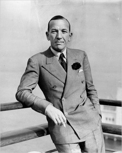 Noel Coward's broad double-breasted suit with its smooth chest adds breath and proportion to his torso.