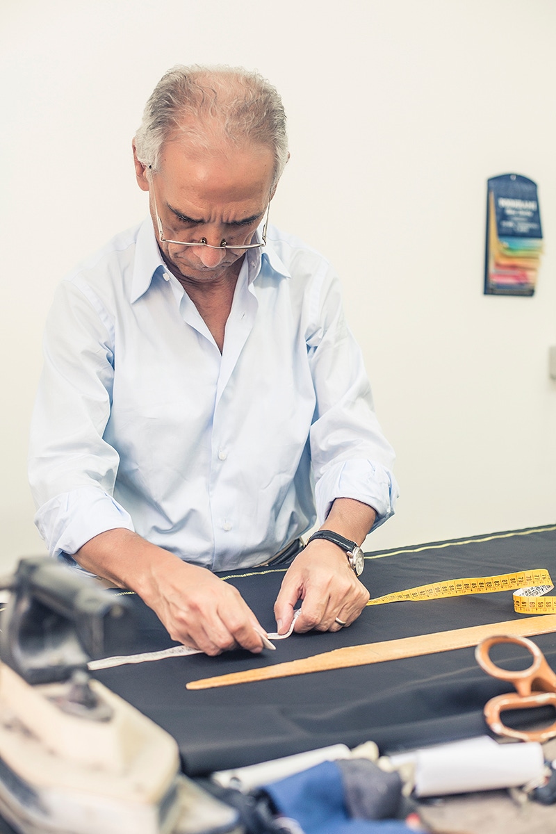 Antonio Ambrosi checks the pattern of a pair of trousers.