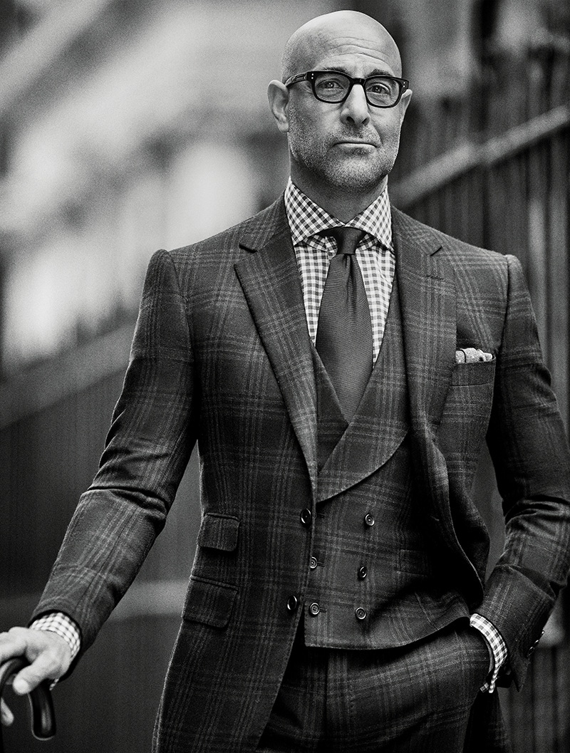 Charcoal-grey large-checked three-piece suit with shawl lapel double-breasted waistcoat, grey and white check cotton shirt and onyx-black silk twill tie, all Cifonelli. Charcoal-grey and ivory silk spotted pocket handkerchief, property of The Rake; black acetate spectacles, E.B. Meyrowitz, property of Stanley Tucci.