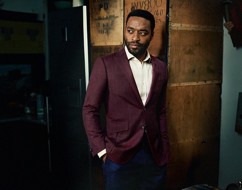 Raspberry purple suit jacket with safari-style pockets, Canali at Harrods; ivory silk shirt, Ralph Lauren Purple Label; navy linen trousers, Anderson & Sheppard Haberdashery.