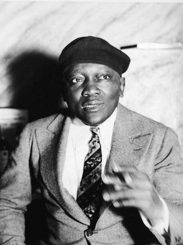 Jack Johnson smoking a cigar, circa 1930. Photo by Lass