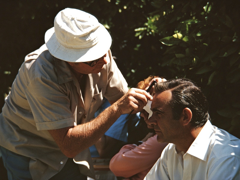 A member of the crew combs Sean Connery's 'hair' on the set of the James Bond film 'Diamonds Are Forever',1971. Photo by Anwar Hussein/Getty Images.