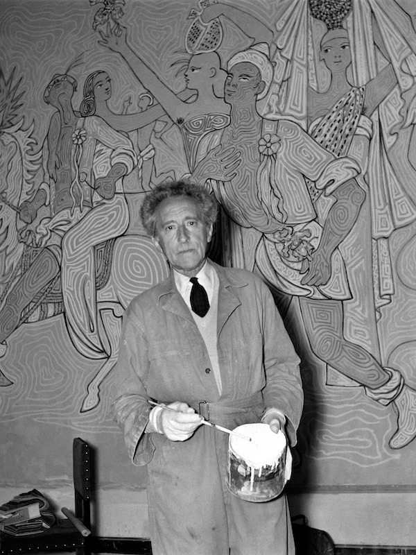 Jean Cocteau in front of a fresco he painted inside the wedding hall of Menton (southern France), 1957. Photograoh by Jean Meunire/AFP/Getty Images.