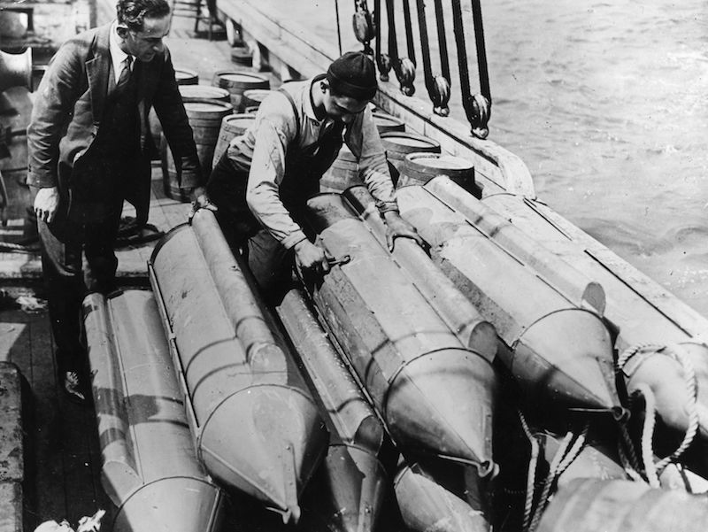 US customs officials examine steel torpodoes on the schooner 'Rosie'. The torpodoes are filled with whisky and  designed to be towed undetected through the water to beat Prohibition in the USA.  Photo by Topical Press Agency/Getty Images.