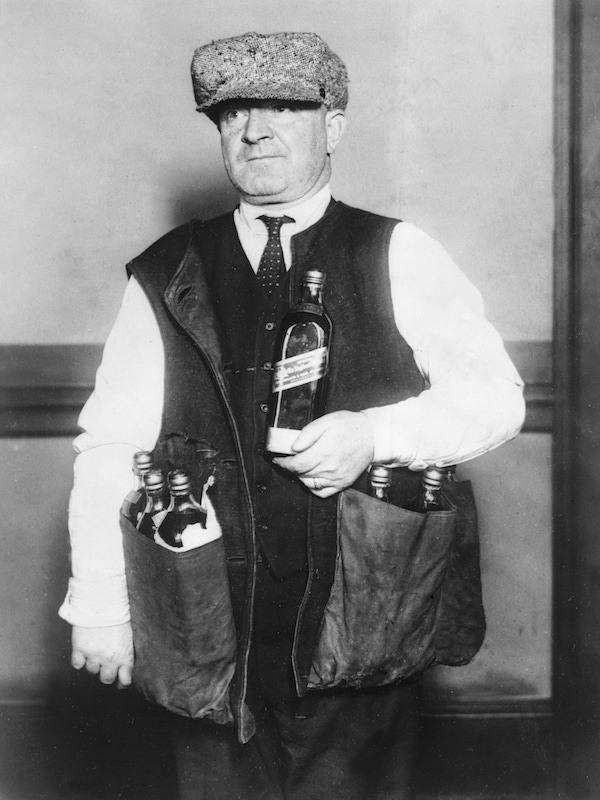 January 1923:  A revenue agent wearing a waistcoat designed to hide whisky during the prohibition era in America.  Photo by Topical Press Agency/Getty Images.