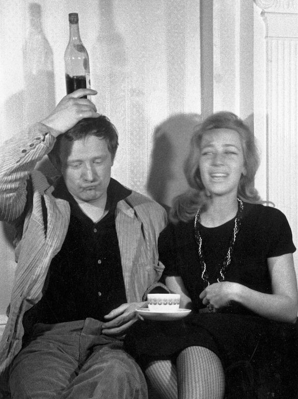 Richard Harris balances a bottle on his head, next to his wife Elizabeth. Photo by Evening Standard/Getty Images.