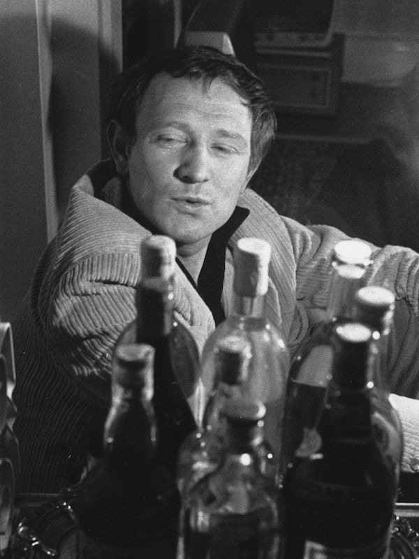 Richard Harris surveys an impressive collection of bottles, perhaps considering his next choice. Photo by Evening Standard/Getty Images.