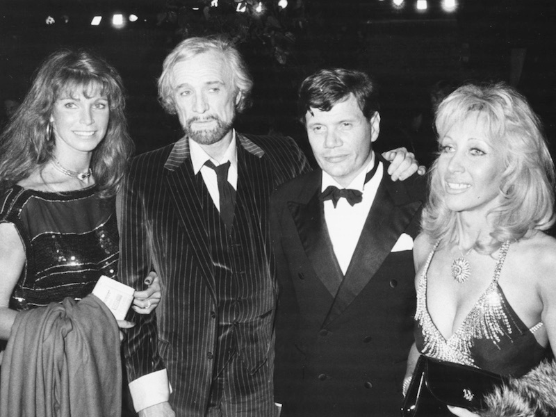 Actress Elizabeth Rees-Williams (right) with her husband Peter Aitken, ex-husband Richard Harris, and actress Ann Turkel, attending a performance of the play 'Camelot' at the Apollo Theatre, 1982. Photo by Dave Hogan/Getty Images.