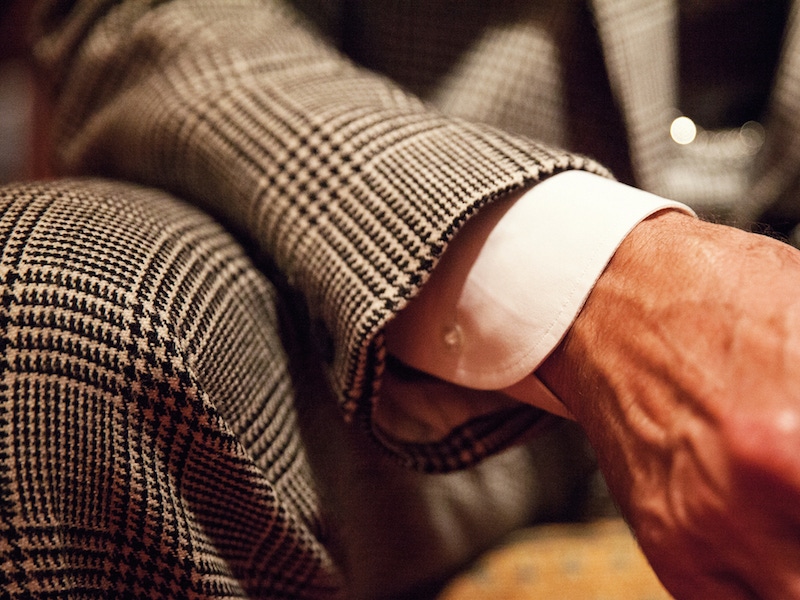 A classic button-cuff shirt — and all the working buttonholes buttoned on his jacket — are a must. He never wears a wristwatch with a suit, only a pocket watch.