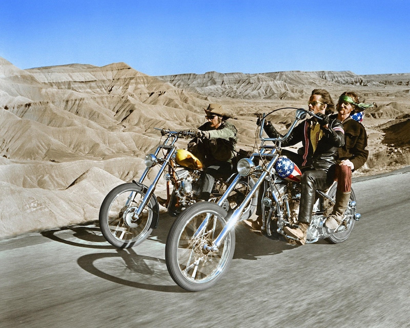 Dennis Hopper (1936-2010), US actor, and Peter Fonda, US actor, riding their chopper motorcycles, with Luke Askew, US actor, on the back of Fonda's motorcycle, in a publicity still issued for the film, 'Easy Rider', USA, 1969. Photo by Silver Screen Collection/Getty Images.