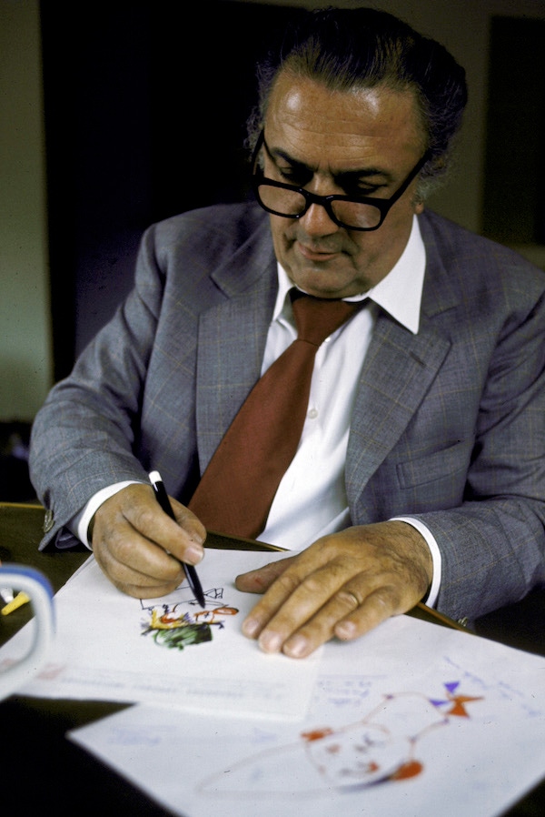 In his studio at Rome's Cinecitta movie center Director Federico Fellini draws endless faces and costumes sketches for the motion picture The Clowns.  Photo by Carlo Bavagnoli/The LIFE Picture Collection/Getty Images.