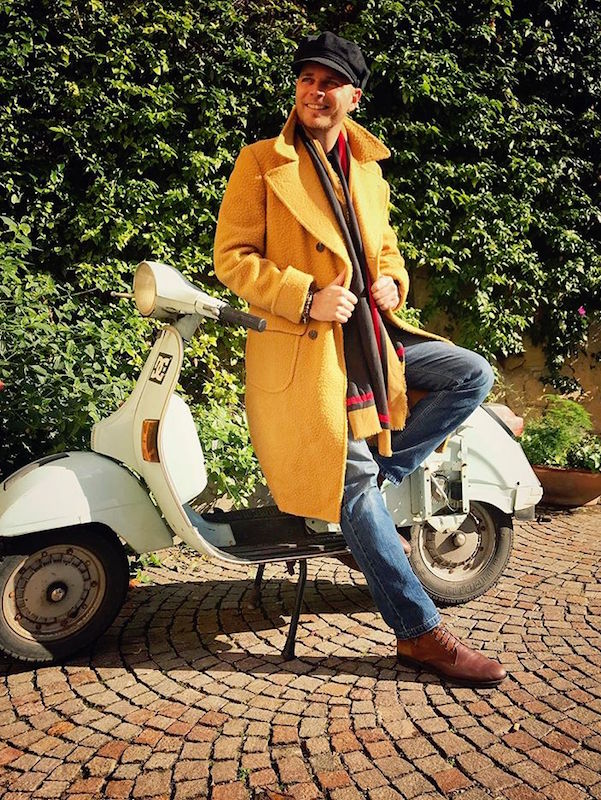 Luca Rubinacci (of the eponymous tailoring brand) takes the Casentino for a spin on his vespa and dresses the coat down with jeans and a peaked cap.