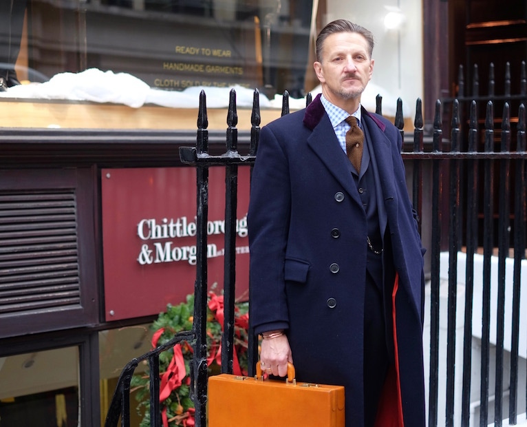 Believe it or not, Clive’s hefty covert coat is well over fifty years old. One of his prized vintage finds, its tailored in bulletproof midnight blue serge and is trimmed in a dashing crimson satin lining. It was made by Bernard Weatherill in the 60s.