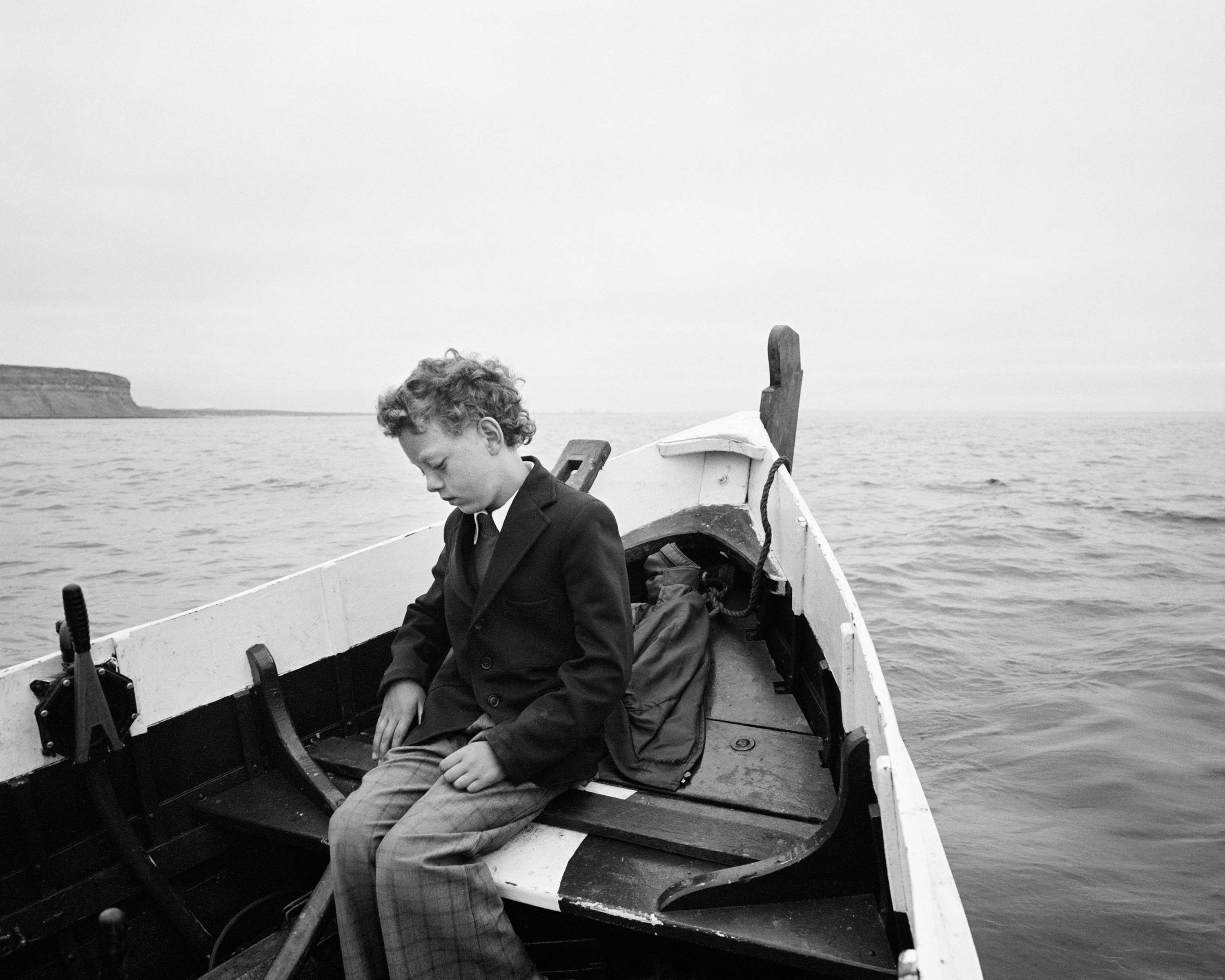 Simon being taken to sea for the first time since his father drowned, Skinningrove, North Yorkshire, 1983, by Chris Killip.
