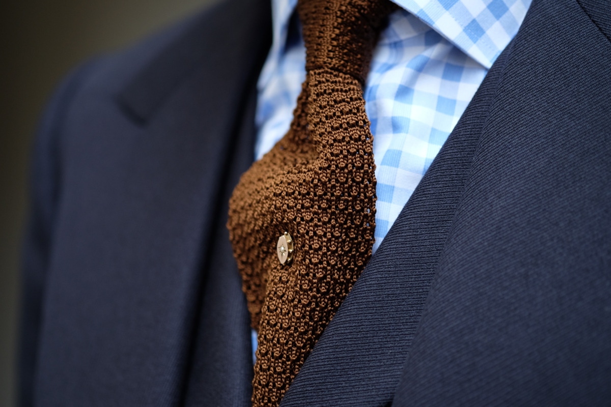 In rakish fashion, Clive is a fan of strong checked shirts and wide spread collars. The tie is a glorious copper knitted silk piece from Turnbull & Asser, and the pin was another piece of his grandfather’s.