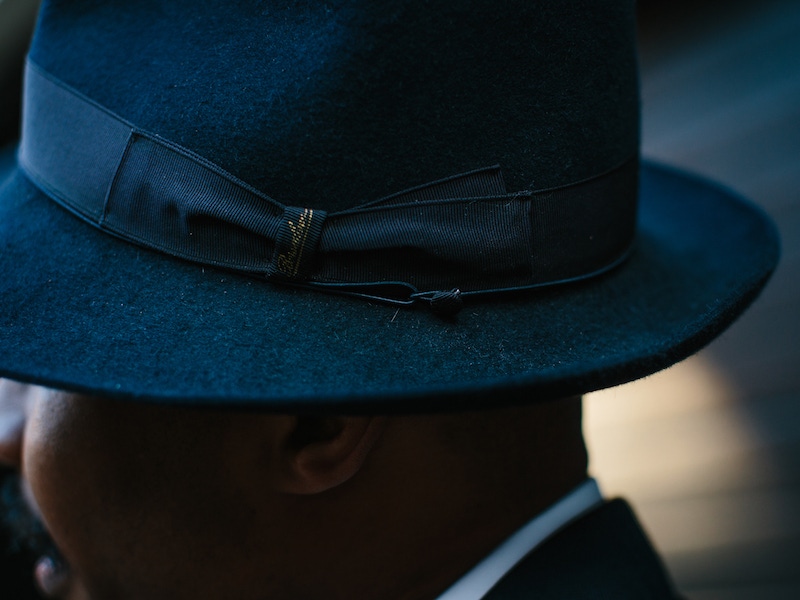 Shaun wears a navy rabbit fur trilby with a tall teardrop crown from Borsalino. A favourite of his, “I wear it pretty much the whole time, and it goes really well with pretty much everything in my wardrobe.” Shaun is very detail orientated, and he loves the mock-bow and the way in which the craftsman at Borsalino tacked it down, so it stays perfectly posed the whole time.