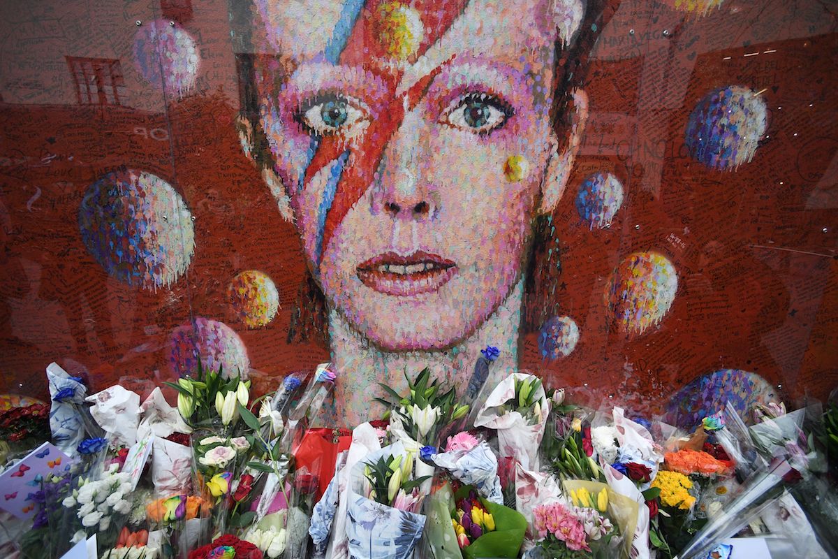 Flowers and tributes are placed by an art work of David Bowie, on his first death anniversary in Brixton, London, 10 January 2017. Photo by Facundo Arrizabalaga/EPA/REX/Shutterstock.