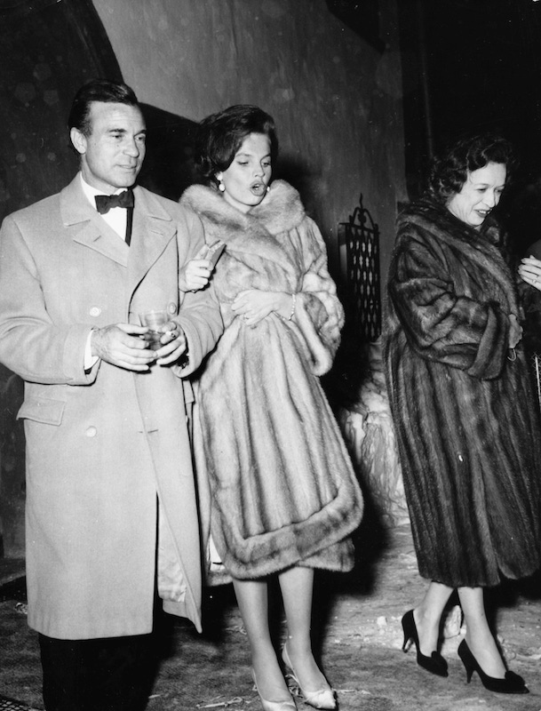 Diplomat and racing driver Porfirio Rubirosa and his wife Odile Rodin (centre) leaving the night club 'Chesa Veglia' in Saint Moritz in Switzerland, circa 1960. Photo by Keystone/Hulton Archive/Getty Images.