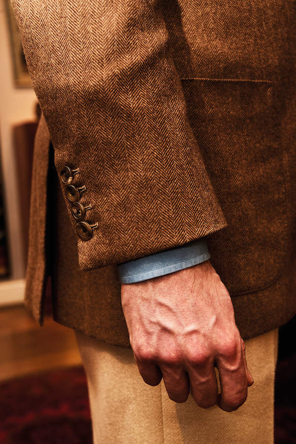 The smallest details mean the most, and Simon likes to wear four buttons on his sports coats instead of the traditional three. This is, however, not the case if he is wearing a Neapolitan jacket, where he sticks to the traditional one-button cuff. The jacket is also a three-roll-two-button assembly, and the patch pockets gives the tweed a truly sporty feel.