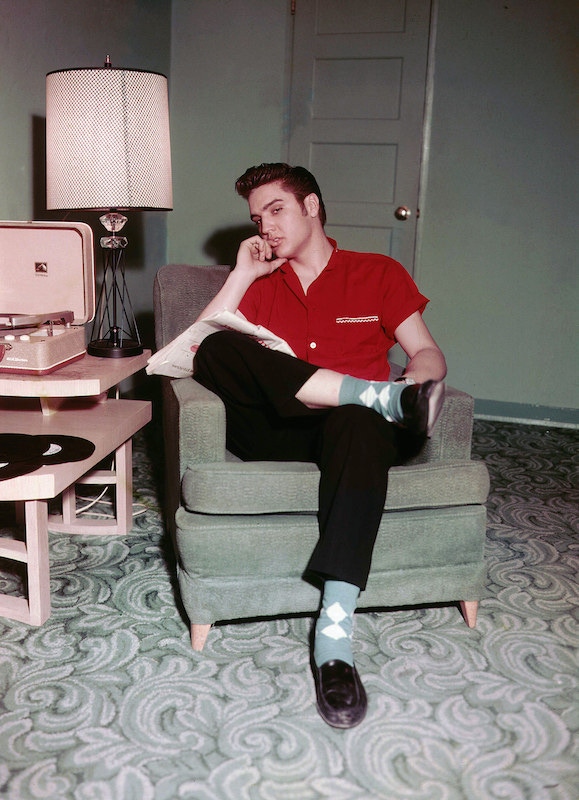 Elvis displaying his trademark insouciance with an argyle sock and penny loafer combination in 1956.