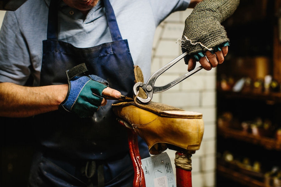 Removing a worn-out sole in the repair shop.