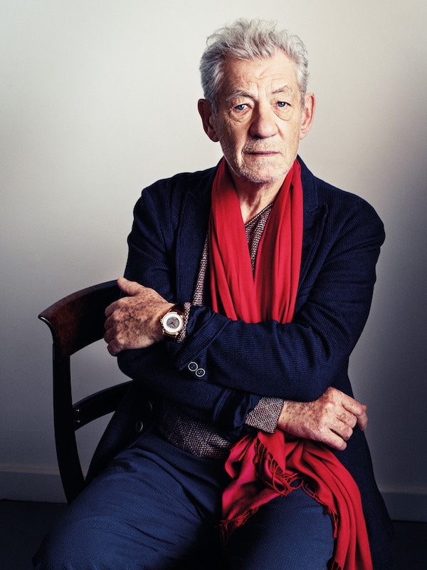 Burgundy diamond pattern cotton sweater and blue-grey cotton drawstring trousers, both Giorgio Armani; navy cotton and linen jacket, John Varvatos; rose gold world time timepiece on chocolate brown alligator leather strap, Patek Philippe.   Magenta silk scarf, property of Sir Ian McKellen.