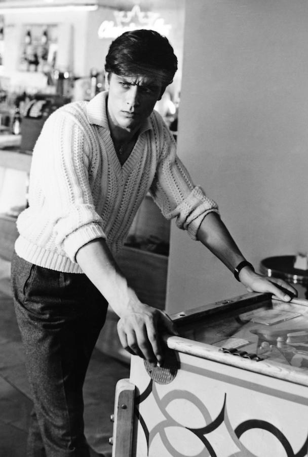 Alain Delon poses by a pinball machine, c. 1955. Photo by Alamy.