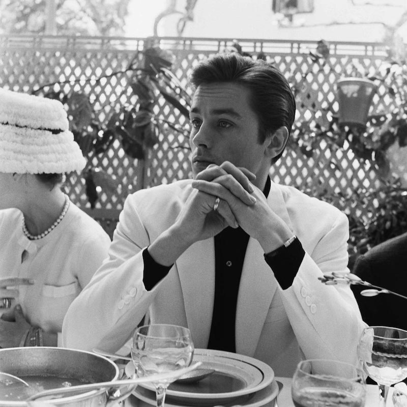 Alain Delon donning his favoured look of a simple tailored suit contrasted against solid colours.