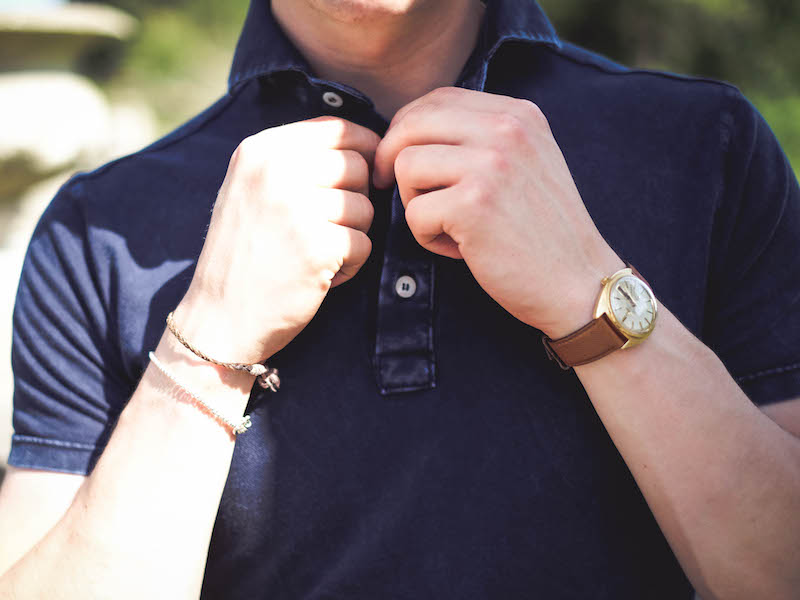 Navy short sleeve pique acid washed cotton polo shirt, Naked Clothing; beige manny pleated cotton trousers, Rubbinacci; watch, vintage Omega, property of The Rake.