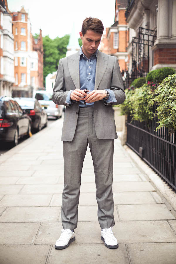 Dark blue long sleeve acid washed pique polo shirt, Naked Clothing; grey suit, Chester Barrie; white sneakers, Brunello Cucinelli; watch, Rolex property of The Rake.