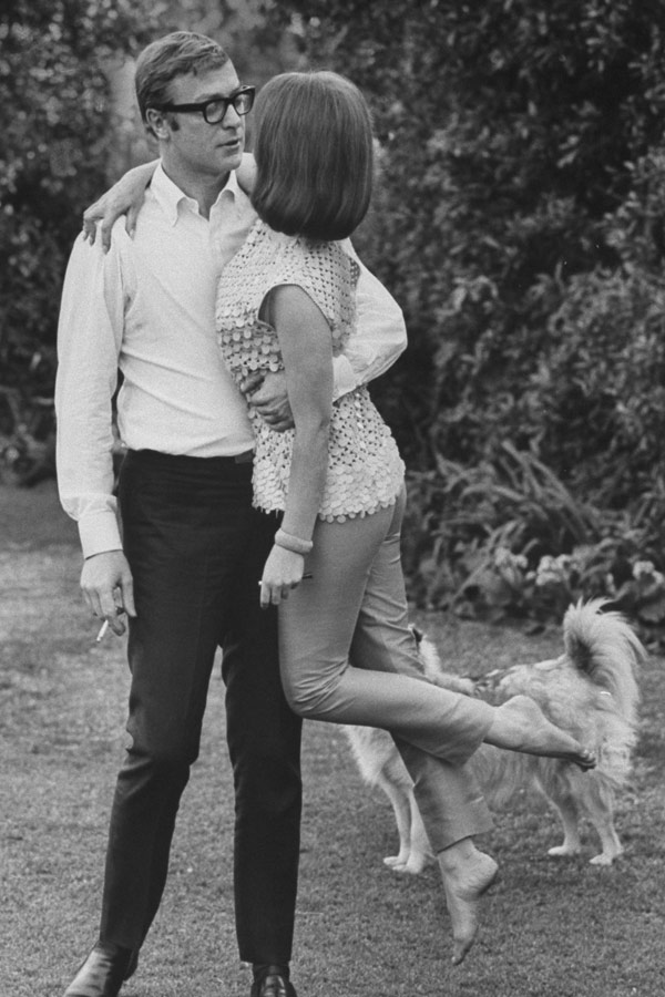 Michael Caine in 1966 with his then-girlfriend, actress Natalie Wood. Caine’s trademark button-down is paired here with slim suit trousers with ‘frog mouth’ pockets and Chelsea boots. Photo by Bill Ray/Time & Life Pictures/Getty Images