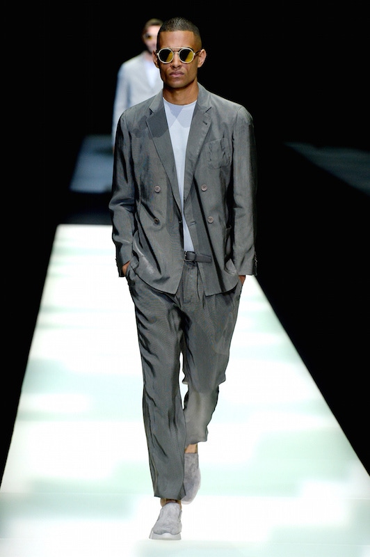 Giorgio Armani: A classic Armani look featuring an unstructured double-breasted suit crafted from a fluid silk-like fabric. Note the pleated, tapered trousers, which sit just above the trainers.