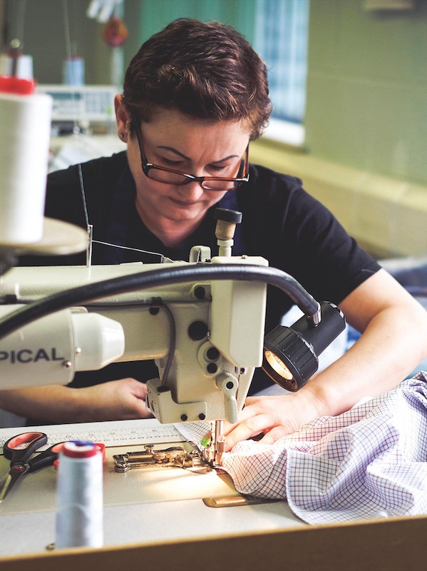 Expert staff at work on the sewing machine in the Gloucester factory. Photo by Justin Hast.