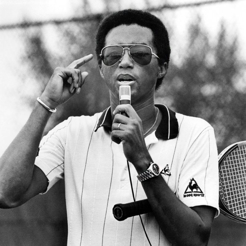 Arthur Ashe opts for a polo by Le Coq Sportif and his signature Rolex Day-Date 'Presidential', in 1981.