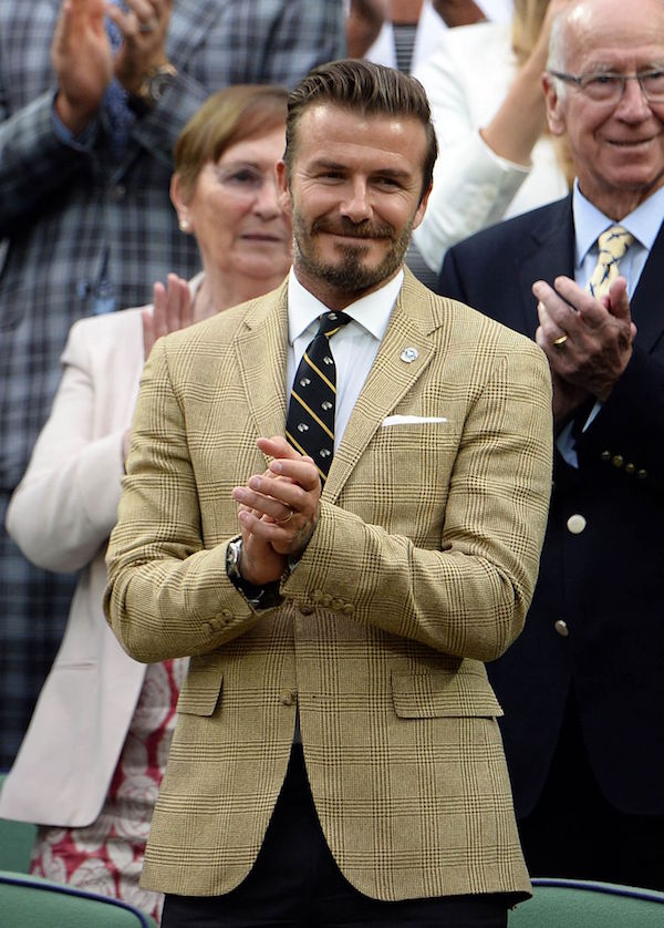 David Beckham masters tonal separates in the stands with a Prince of Wales check and brown trousers, 2014. Photo by Andrew Parsons/REX/Shutterstock.