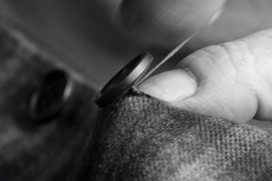 A button being hand-sewn onto a Principe di Eleganza jacket.