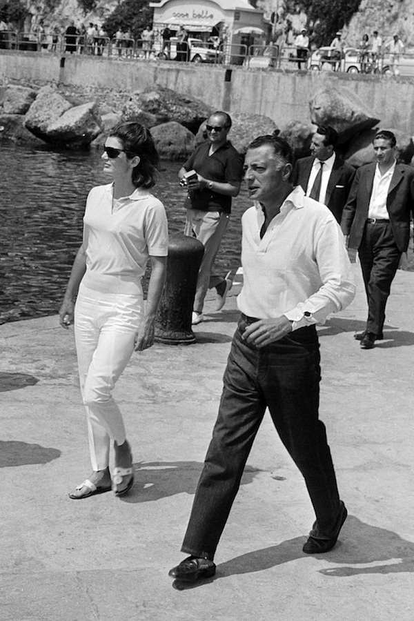 Godfather of the Cote d’Azur, Gianni Agnelli is pictured with Jackie Kennedy as they stroll along a pier in the Amalfi Coast, 1962.