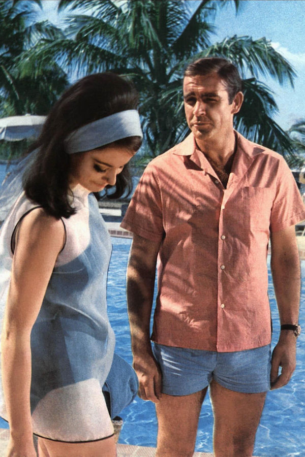 Despite being more well known for his tailoring, Connery’s Bond had an enviable resort wardrobe, including this short-sleeve camp collar shirt and swim short combination, worn alongside Claudine Auger in Thunderball, 1965.