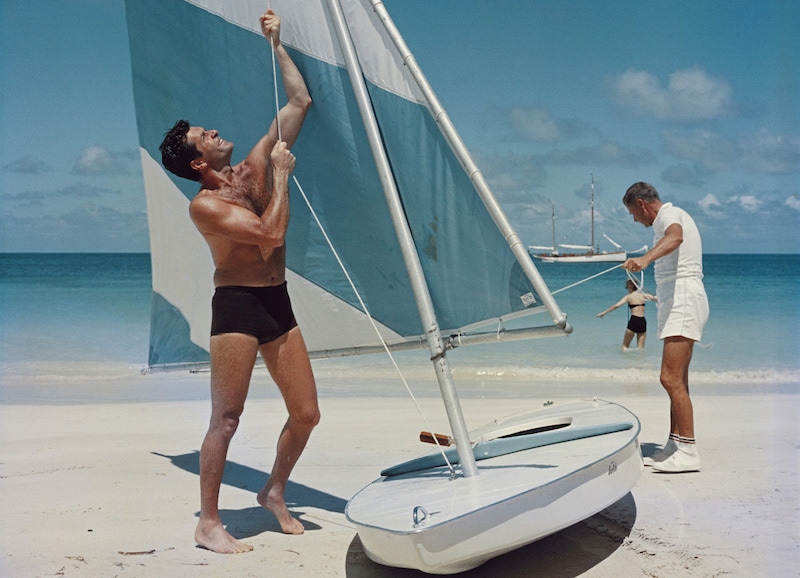 Slim Aarons’ photograph ‘Boating in Antigua’, showing two ways to wear swim shorts, circa 1960s.