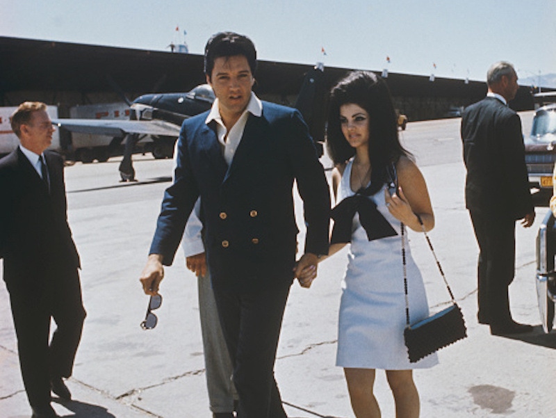 Elvis Presley with Priscilla Presley at an airport during their honeymoon from Las Vegas to Palm Spring, 1967.