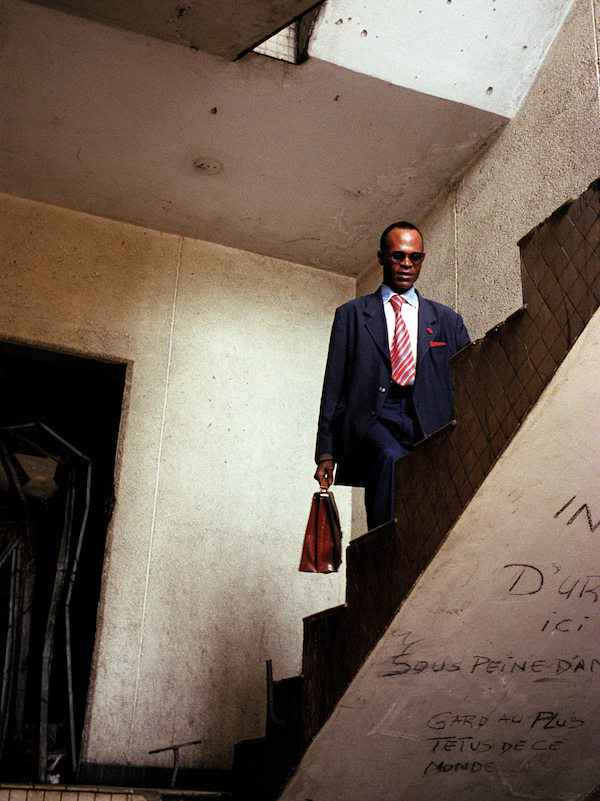 Yves Francois Ngatsongo, also known as Yves Saint Laurent, is the president and founder of the France Libre association. He walks up the stairs of the storey building were he lives in downtown. This building, along with others - damaged by the combats of the last civil war, 1997-2001 - have been squatted in for some time.