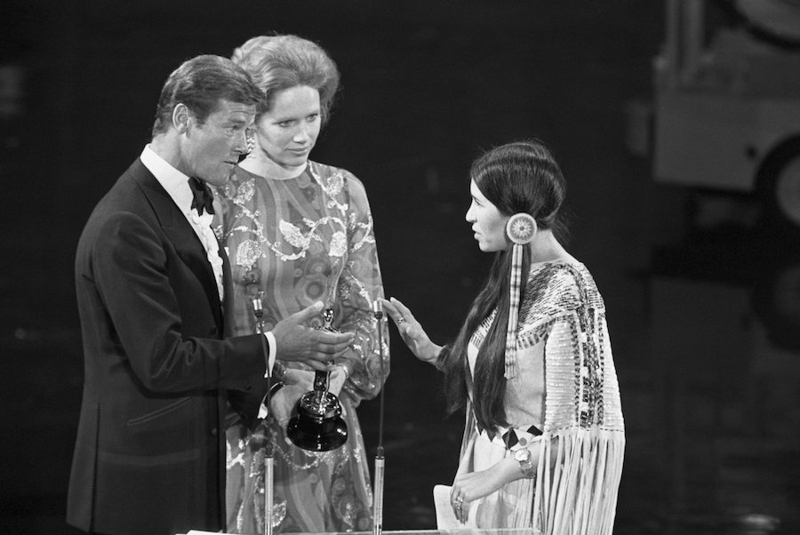 Sacheen Littlefeather rejects the Academy Award for Best Actor on behalf of Marlon Brando (The Godfather) presented by Roger Moore and Liv Ullmann, 1973.