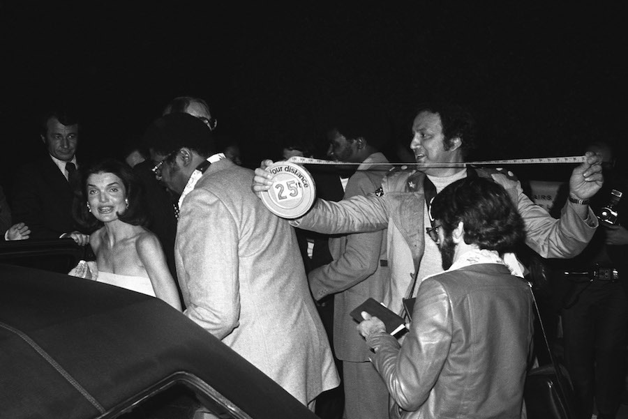 Ron measures his distance not to disobey the court order against Jackie Kennedy in Los Angeles, California, 1976. Photo by Brad Elterman/FilmMagic/Getty Images.