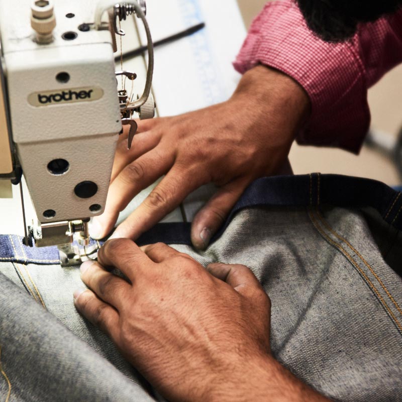 Stitching a pair of jeans together. Photo by Kim Lang.