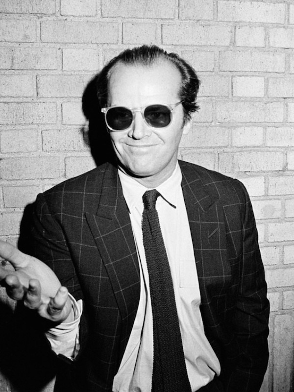 Jack Nicholson wearing his signature sunglasses indoors, circa 1980s.