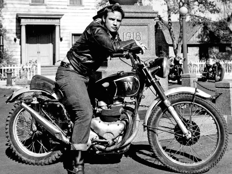 Marlon Brando on the set of The Wild One in 1953, wearing jeans and a leather jacket.