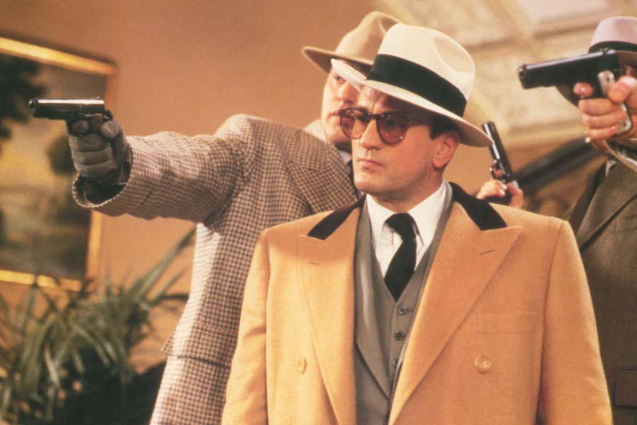 Styled by Armani in The Untouchables, Robert De Niro wears a camel wool-blend overcoat with a contrast collar over a grey three-piece suit, paired with a large felt hat. Photo by Moviestore/REX/Shutterstock.