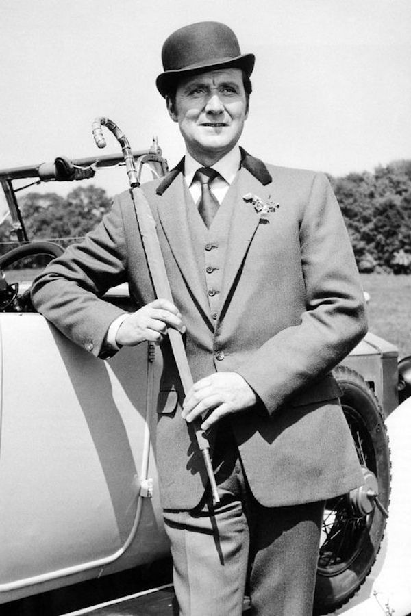 John Steed from the television series 'The Avengers,' played by Patrick Macnee, wears a three-piece suit completed with a velvet-collared coat and bowler hat, circa 1965.