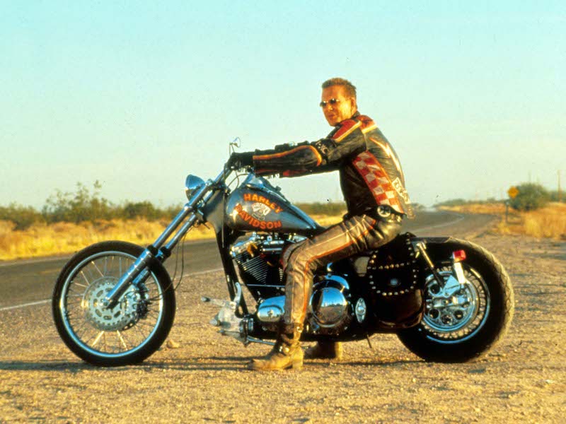 Posing on a Harley Davidson motorcycle in Harley Davidson And The Marlboro Man, 1991. Photo by Moviestore/REX/Shutterstock.