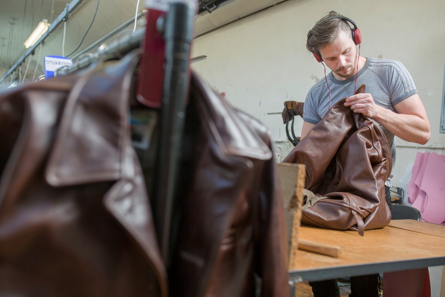 An artisan in Aero Leather's workshop putting the final touches on a jacket.